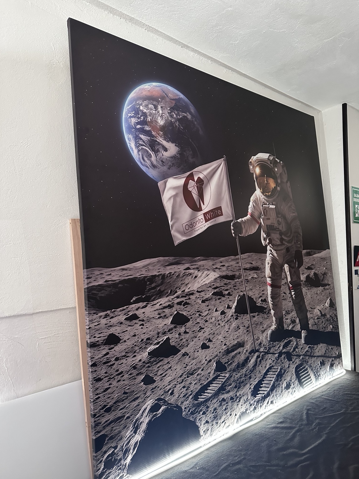 Cuadro de astronauta en lona mate sobre herrería; la luz de la fotografía es escenográfica y no forma parte del producto